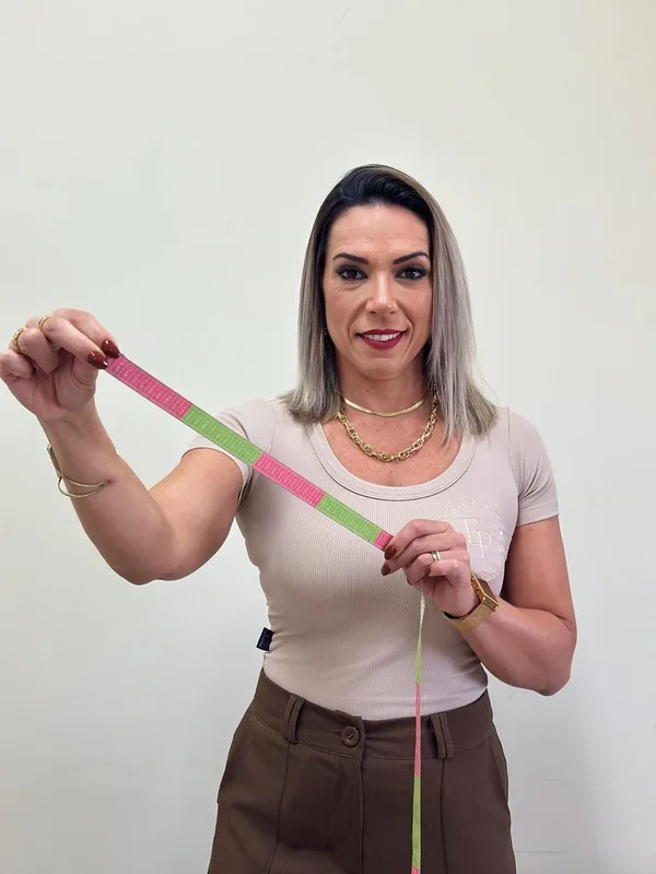 Jaciara Goddoi com fita métrica, representando a avaliação física do acompanhamento nutricional